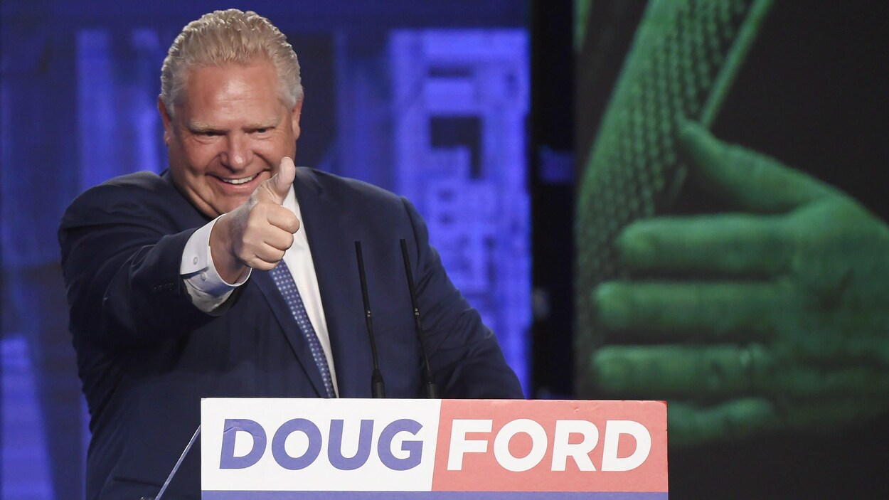 Doug Ford tient le pouce en l'air au podium pour célébrer sa victoire.