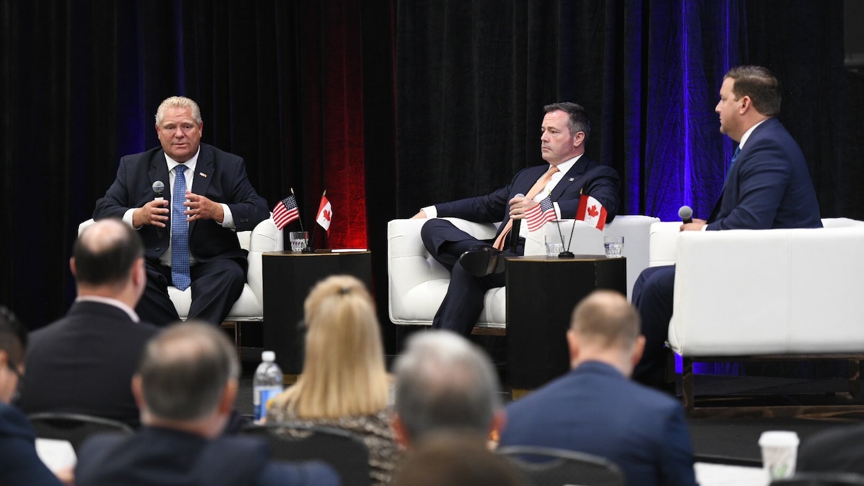 Le premier ministre de l'Ontario, Doug Ford en discussion avec le premier ministre de l'Alberta, Jason Kenney, assis sur une scène et devant des spectateurs.