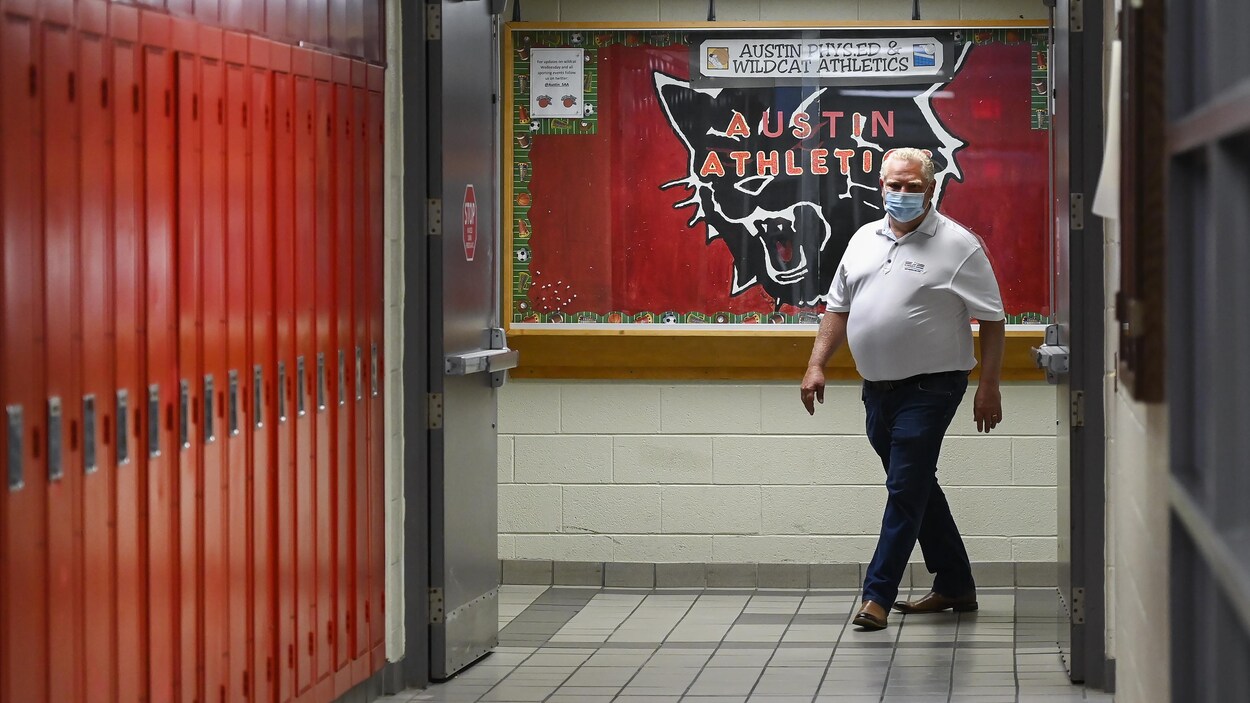 Le premier ministre Doug Ford marche dans le couloir de l'École secondaire catholique Father Leo J Austin de Whitby.