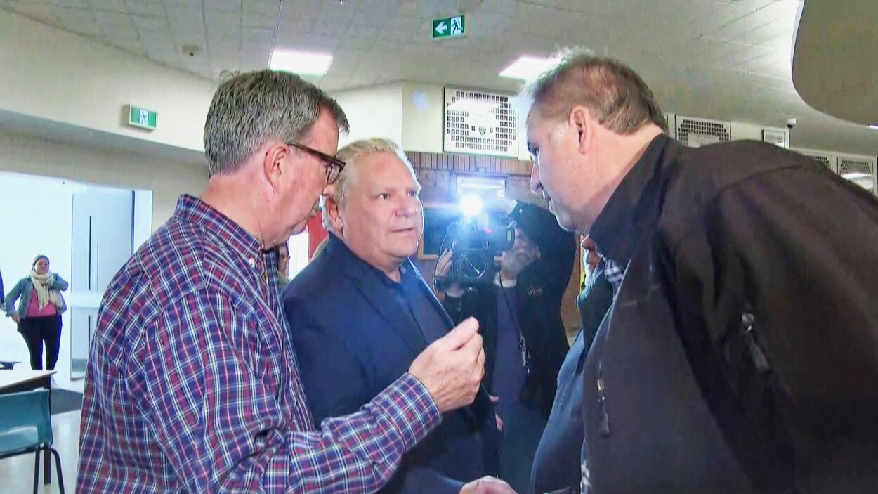 Doug Ford serre la main d'un citoyen, à côté du maire d'Ottawa, Jim Watson.