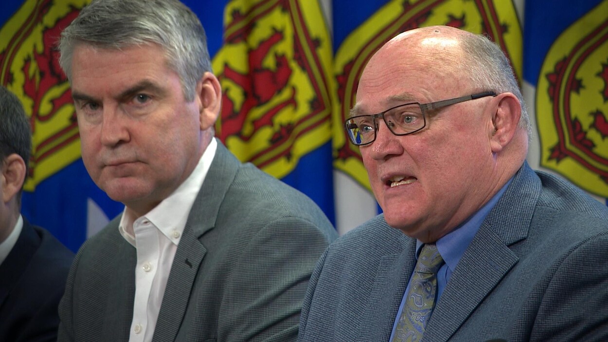 Stephen McNeil et Robert Strang devant des drapeaux de la Nouvelle-Écosse.
