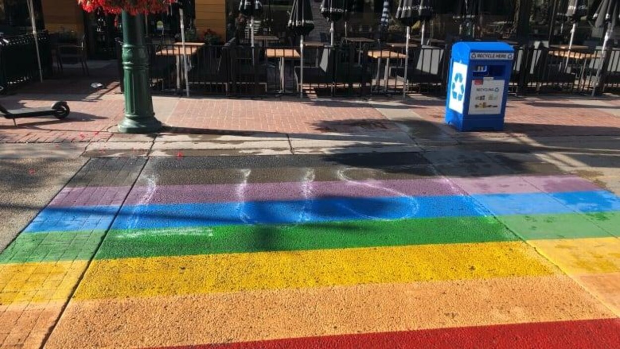 Le mot « Lust » ou luxure est écrit sur le passage pour piétons arc-en-ciel peint à une intersection du centre-ville de Calgary.