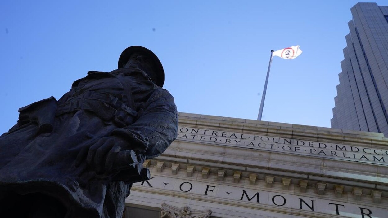 Un drapeau blanc avec un cercle rouge flotte au-dessus d'un bâtiment avec des colonnes.