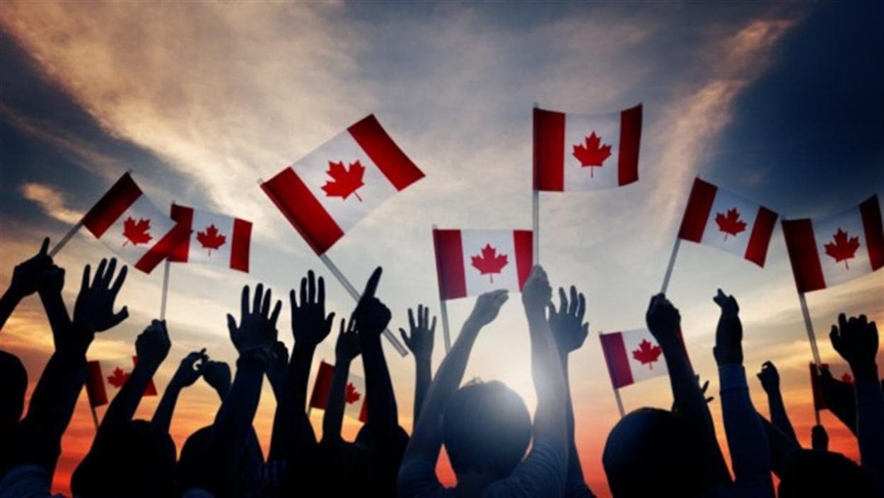 Une foule agite dans les airs des drapeaux canadiens. Une foule agite dans les airs des drapeaux canadiens.