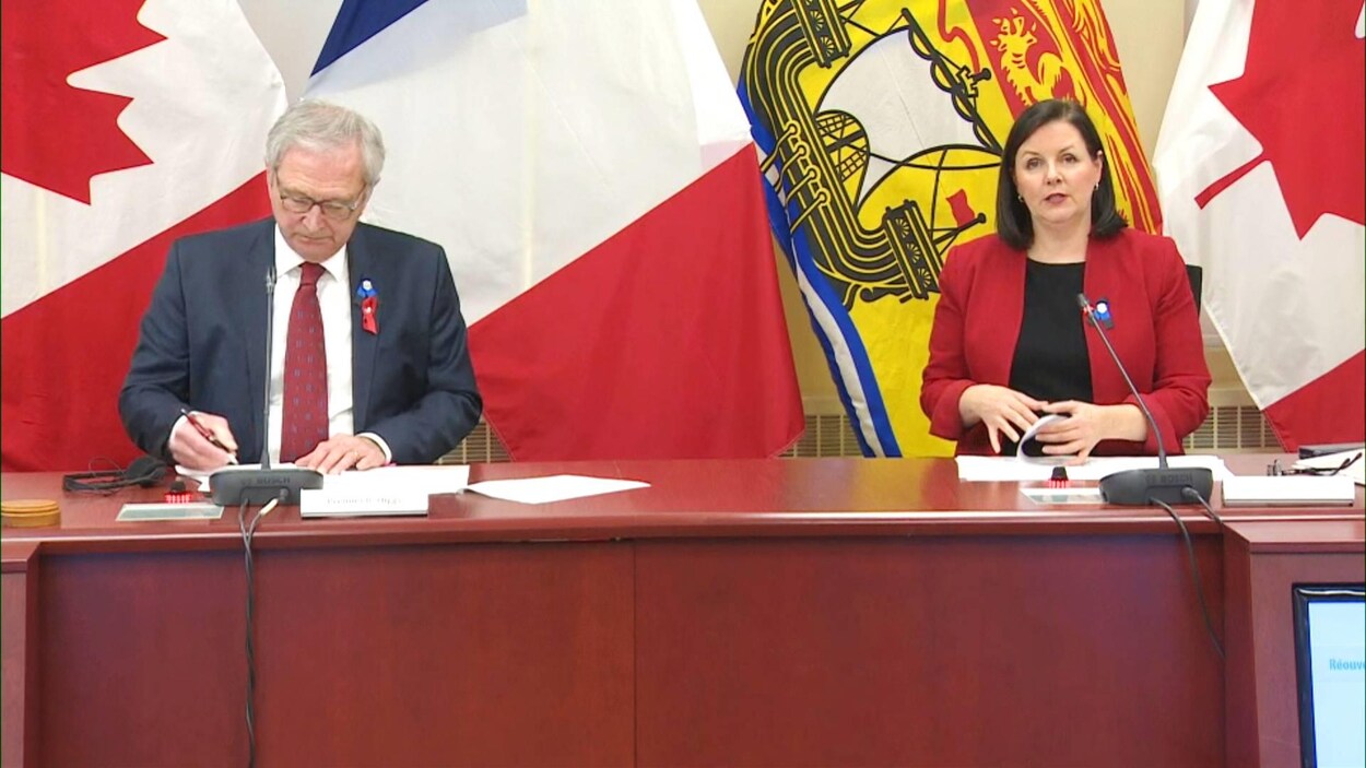 Blaine Higgs écrit sur une feuille et Jennifer Russell parle.