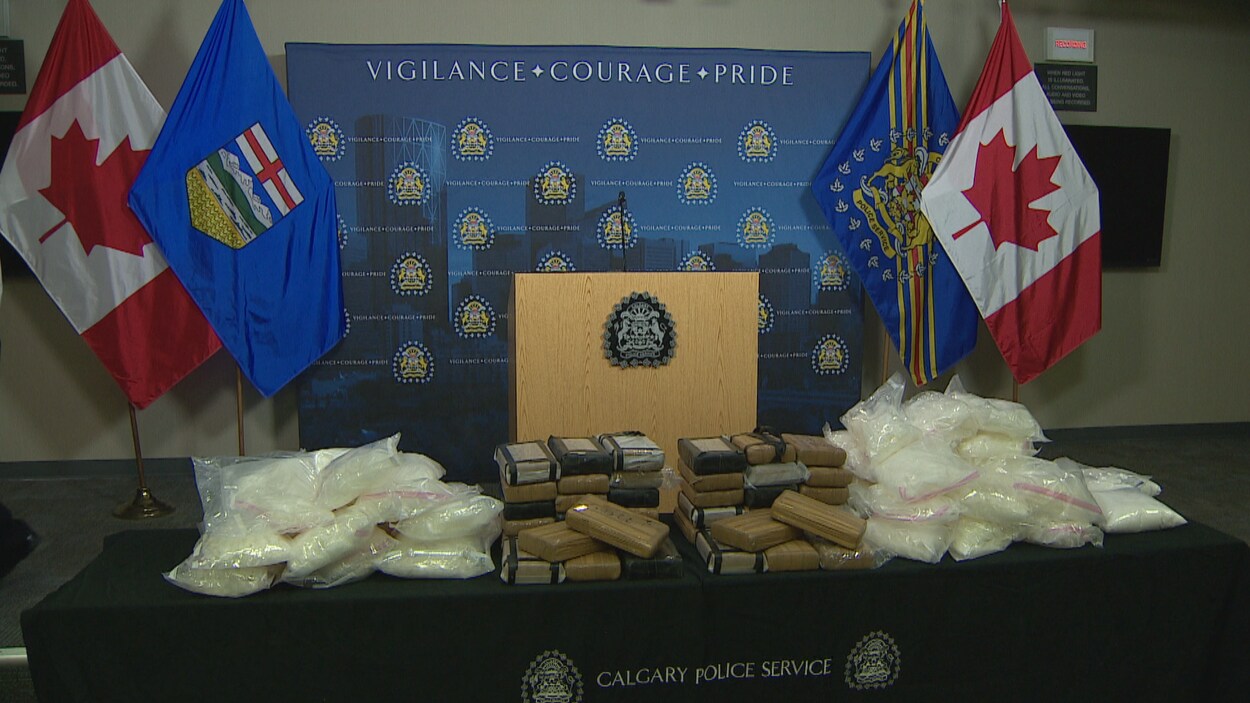 46,9 kg de cocaïne en brique et 47,5 kg de cristaux de méthamphétamine sur une table.