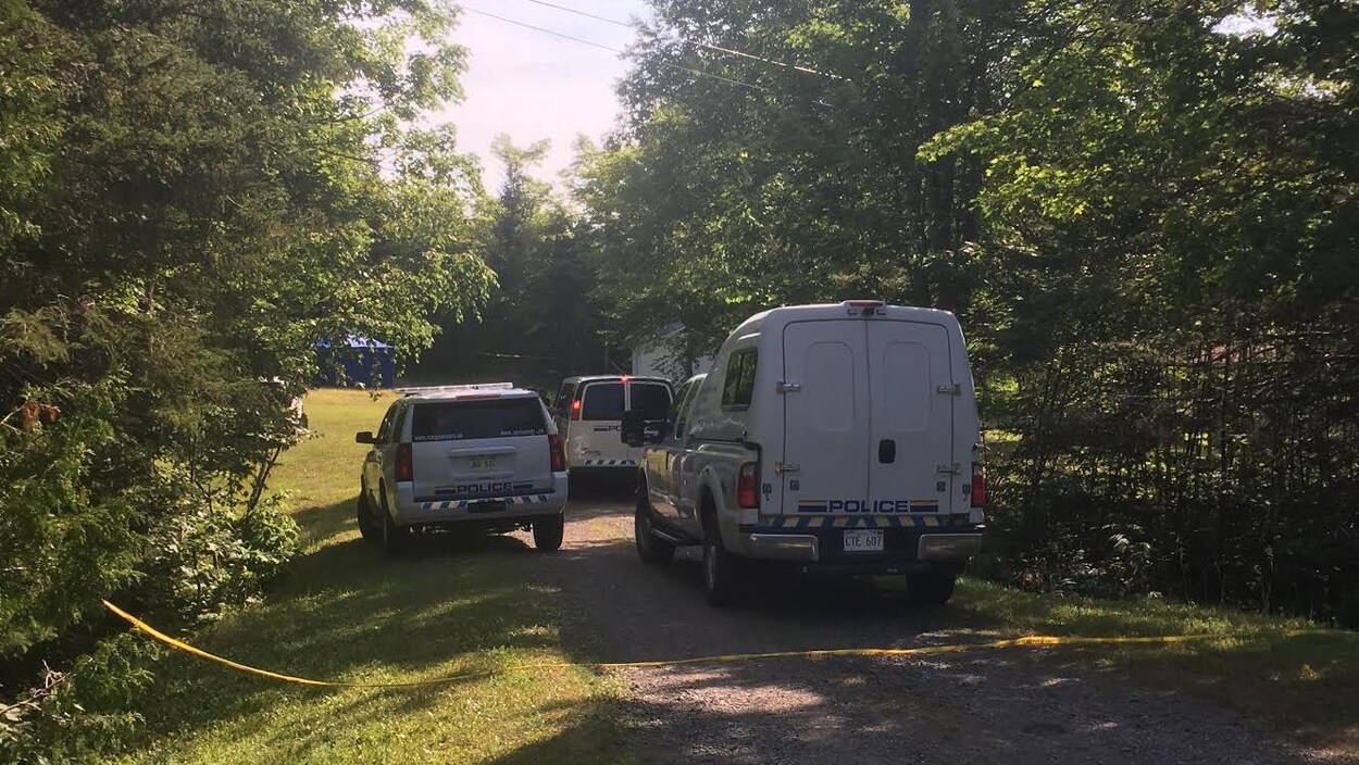 Trois véhicules de la Gendarmerie royale du Canada bloque l'entrée de la propriété.