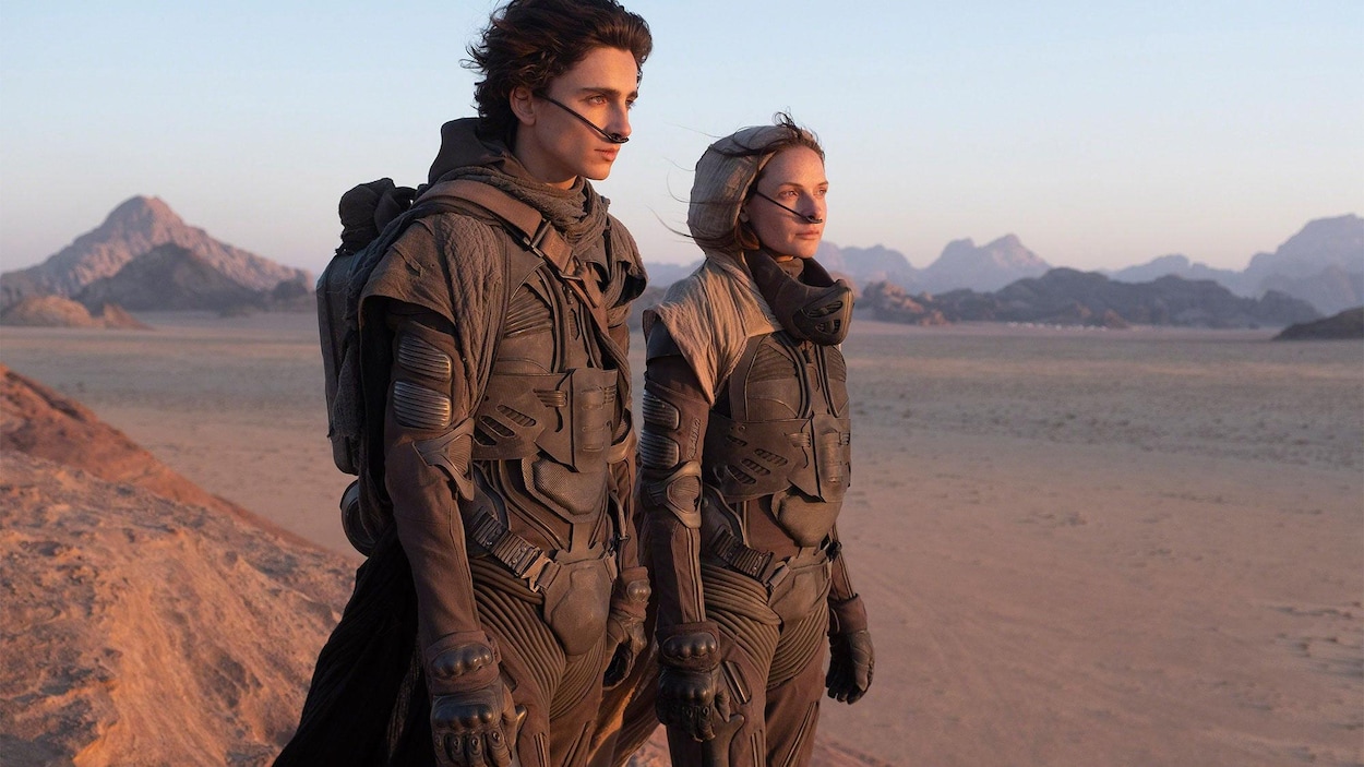 Un homme et une femme debout dans le désert avec des fils dans le nez.