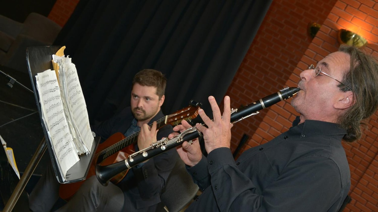 Deux hommes jouent de la musique.