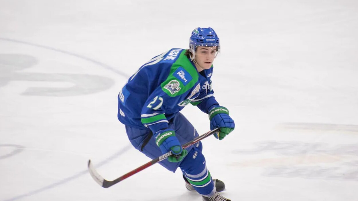Un défenseur des Mustangs de Melfort, Dylan Ashe, est sur la glace avec son bâton et son uniforme de hockeyeur.