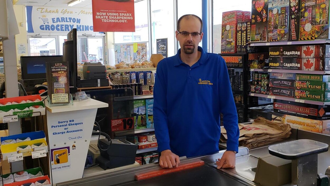 Michel Maurice, derrière la caisse, dans l'épicerie d'Earlton.