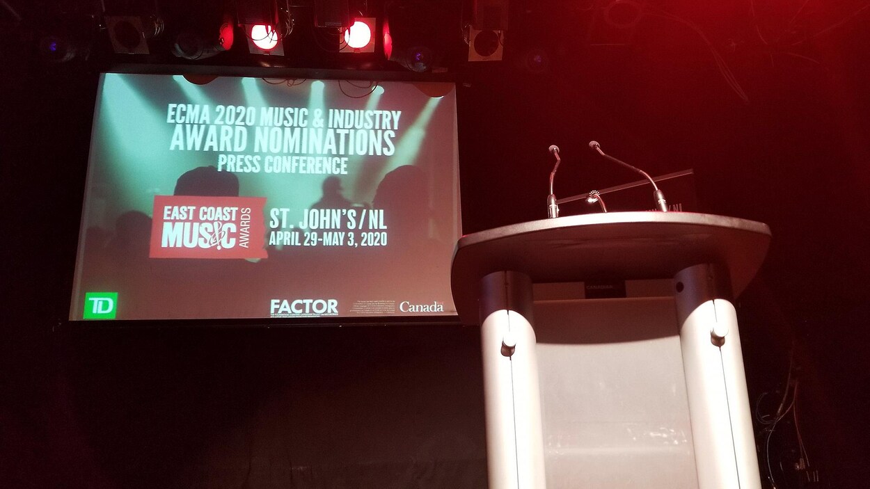 Une scène avec un lutrin et un écran géant sur lequel on peut lire : ECMA 2020 MUSIC & INDUSTRY AWARD NOMINATIONS PRESSE CONFERENCE.
