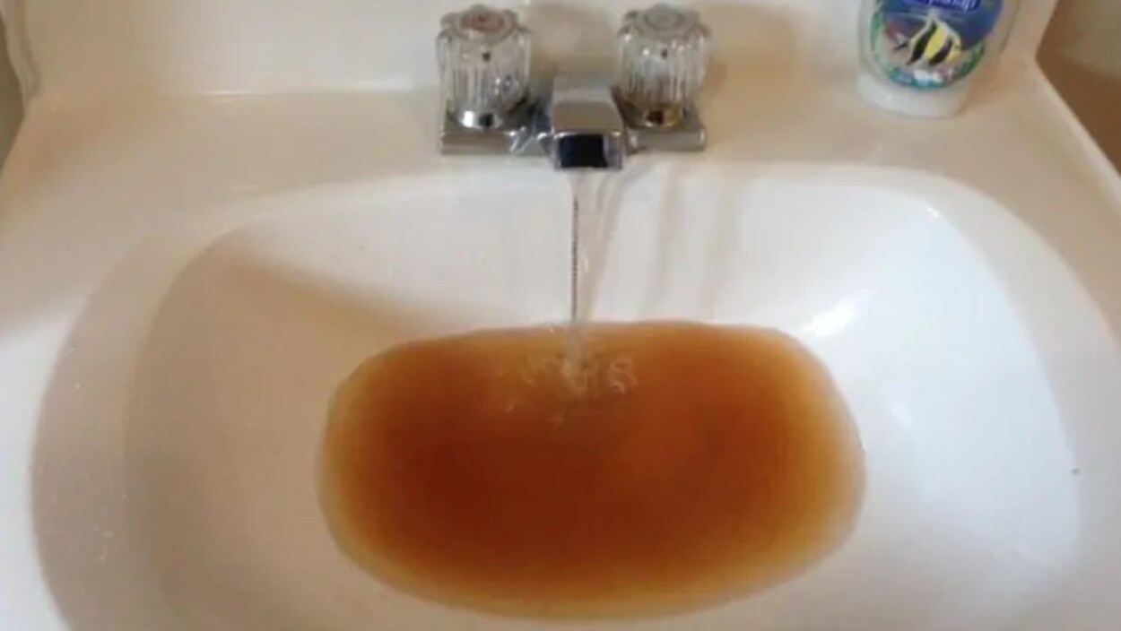 Une eau sale coule dans un lavabo