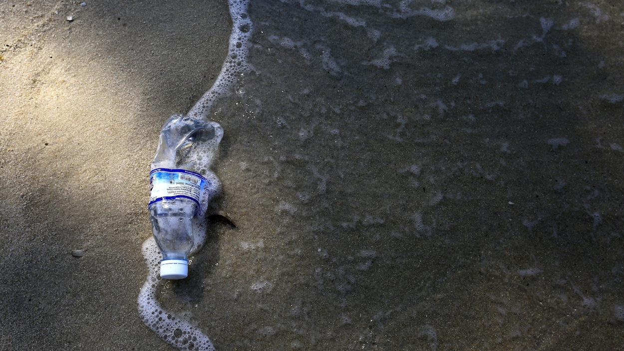 Une bouteille de plastique sur une plage.