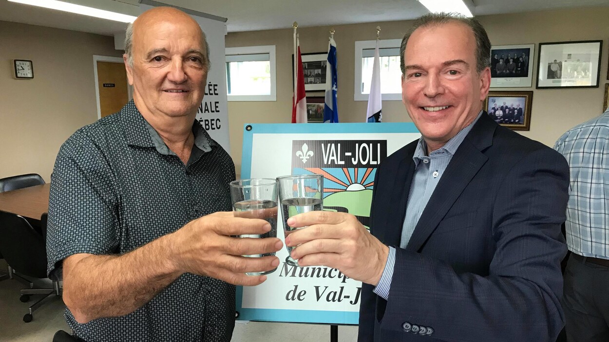 Les deux hommes trinquent avec un verre d'eau.