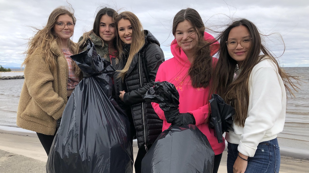 Adolescentes portant des sacs-poubelle.