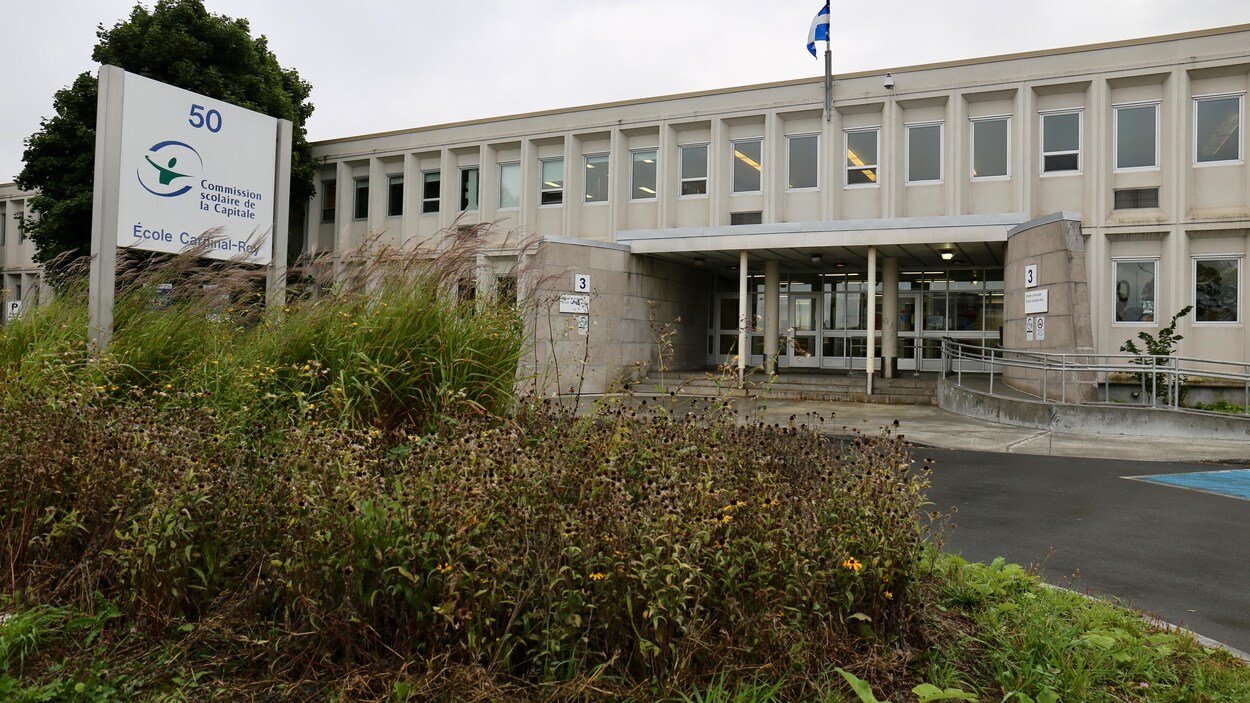 Vue de l'extérieur de l'École secondaire Cardinal-Roy, à Québec, avec une affiche de la Commission scolaire de la Capitale.