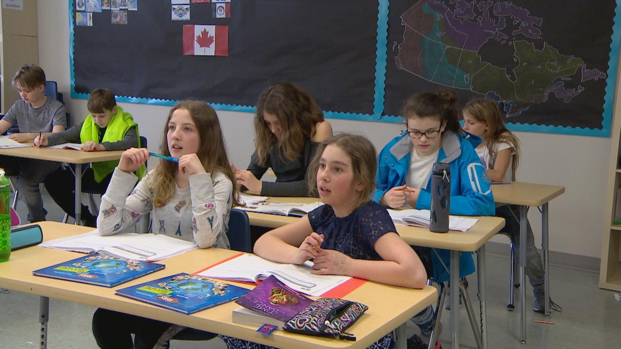 Des élèves dans une salle de classe. Quatre filles d'environ dix ans sont assises à un pupitre. Des élèves dans une salle de classe. Quatre filles d'environ dix ans sont assises à un pupitre.