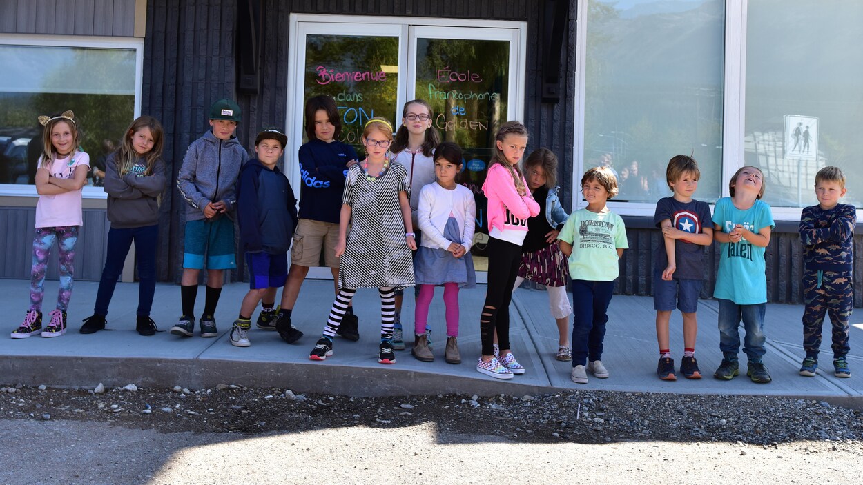 Des enfants posent devant leur école.