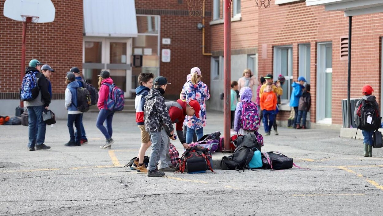 Des jeunes élèves dans une cour d'école.