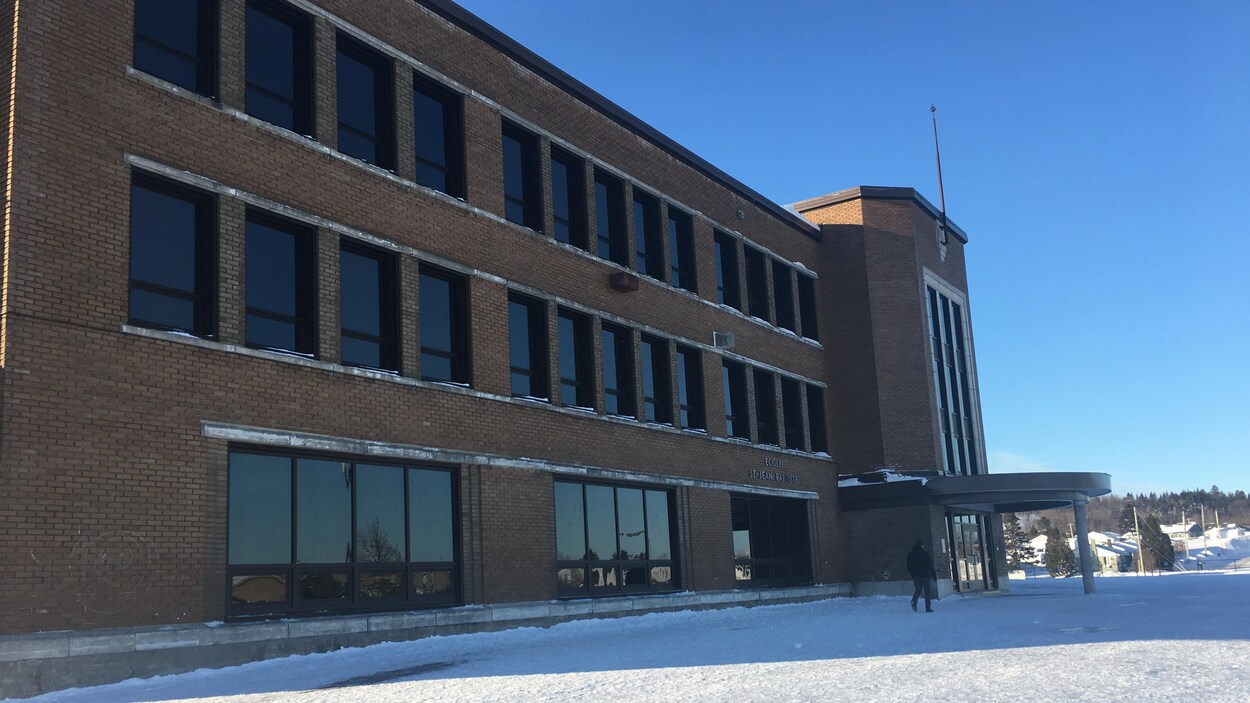 L'édifice de l'école Saint-Jean-Baptiste vu de la cour d'école en hiver.