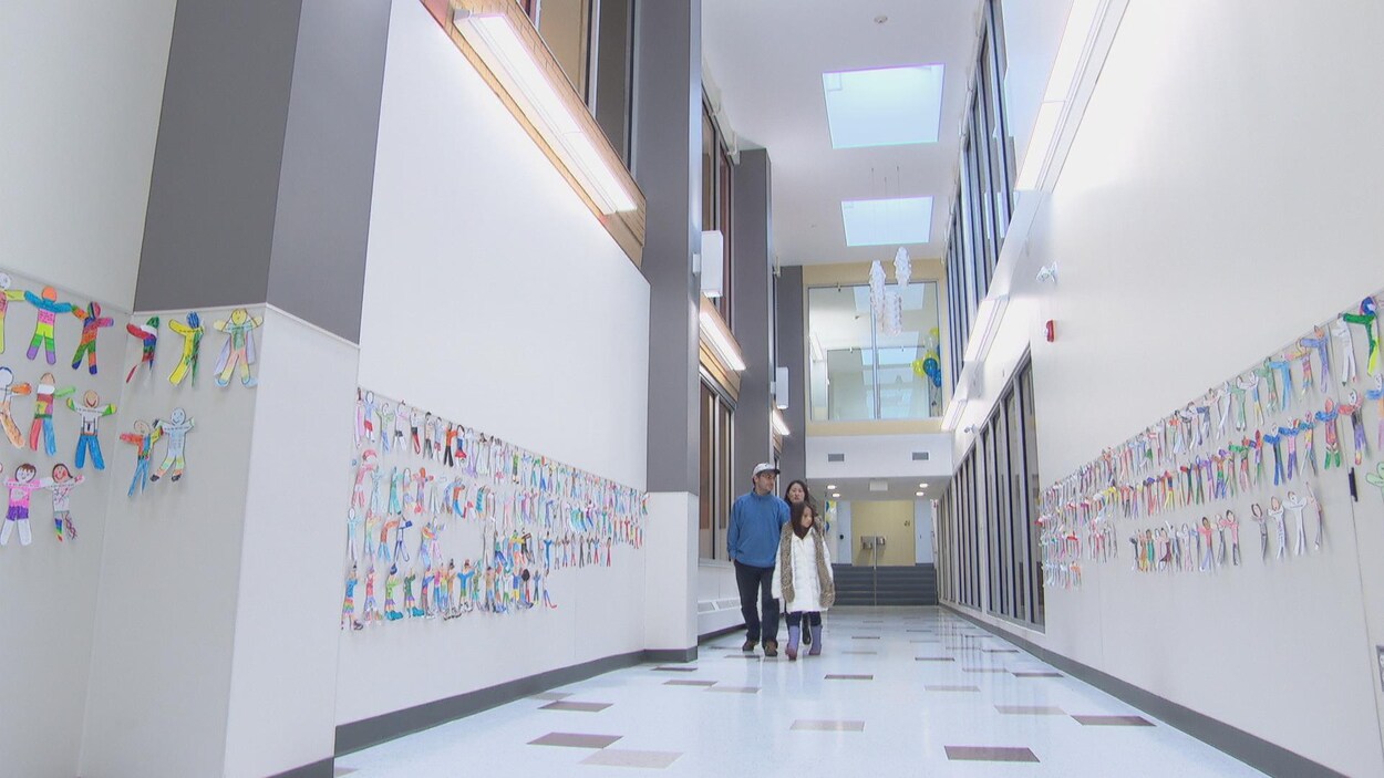 Une famille arpente un couloir neuf et décoré de l'École élémentaire catholique Sainte-Geneviève, à Ottawa.