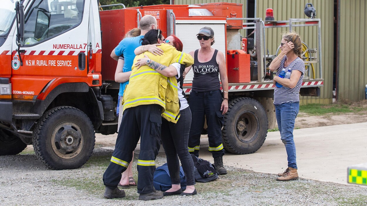 Des gens se consolent après avoir appris qu'ils avaient perdu des collègues pompiers dans un écrasement d'avion.
