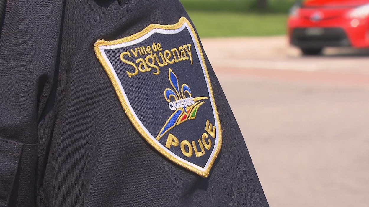 Un écusson du Service de police de Saguenay apparaît sur la manche d'une chemise.