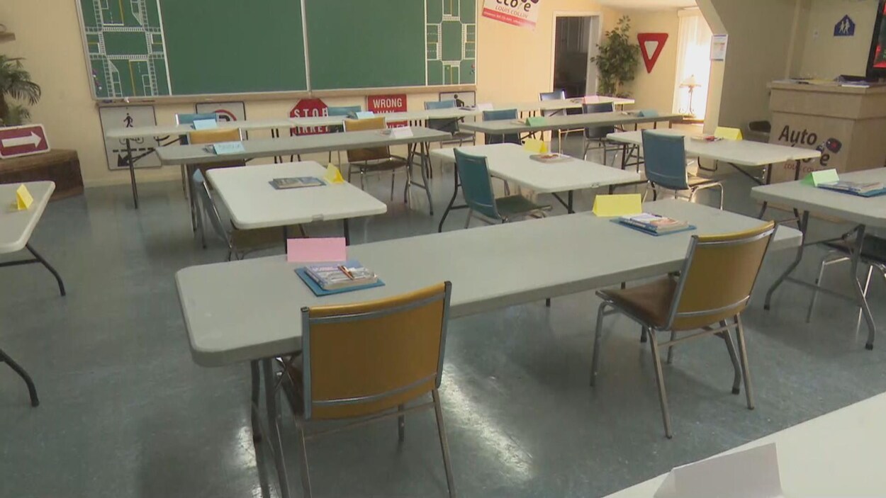 Des tables et des chaises disposées à une bonne distance les unes des autres dans une salle de classe.
