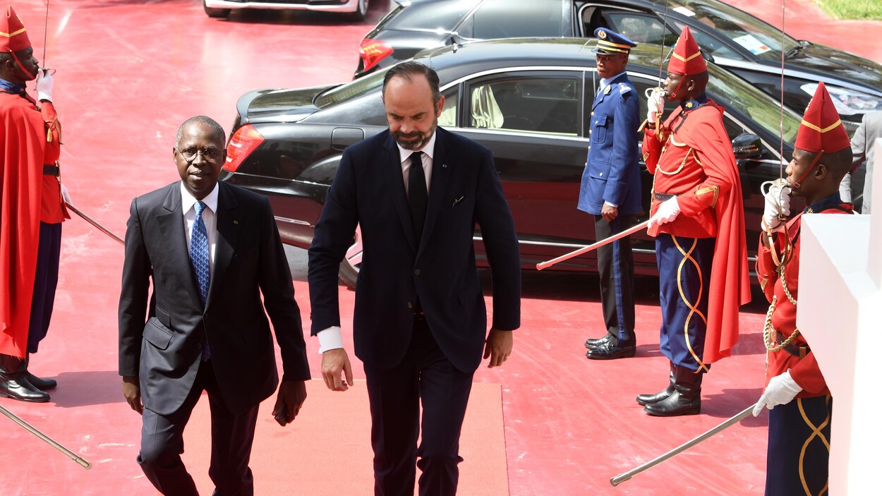 Édouard Philippe monte un escalier devant une garde d'honneur sénégalaise.