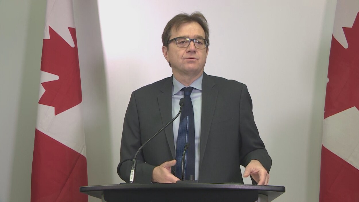 Un homme debout parle au micro.
