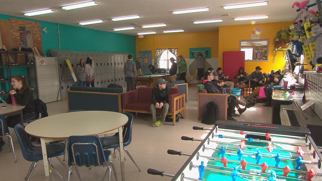 La Maison des jeunes de Dieppe avec un salon, des casiers, des jeux, des jeunes qui discutent.