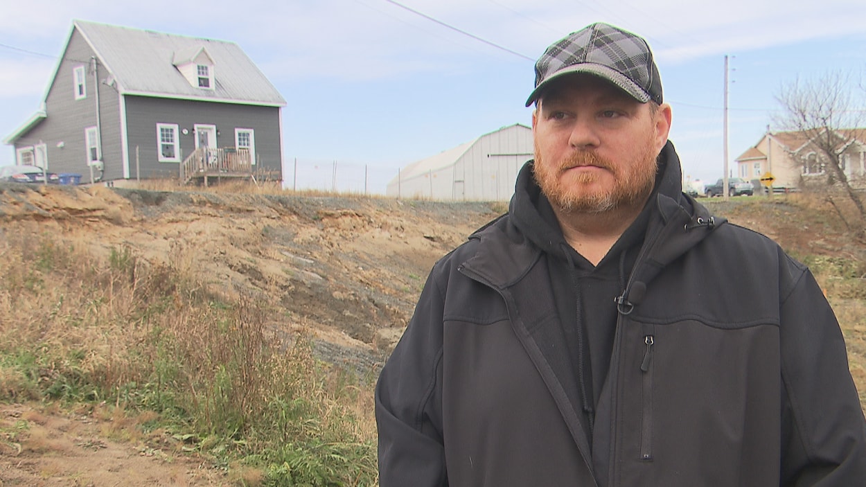 Normand Lavergne debout devant le trou béant et sa maison. Normand Lavergne debout devant le trou béant et sa maison.