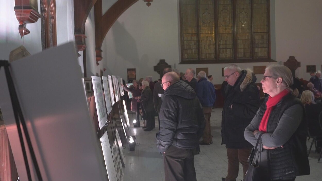 Des citoyens lisent des panneaux explicatifs exposés dans l'ancienne église. Des citoyens lisent des panneaux explicatifs exposés dans l'ancienne église.