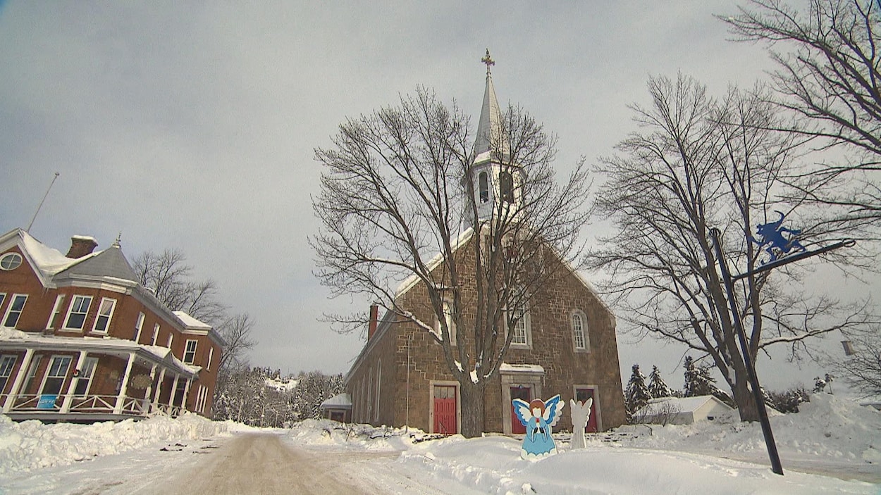 Église de Saint-Élie-de-Caxton en hiver avec un lutin sur un poteau