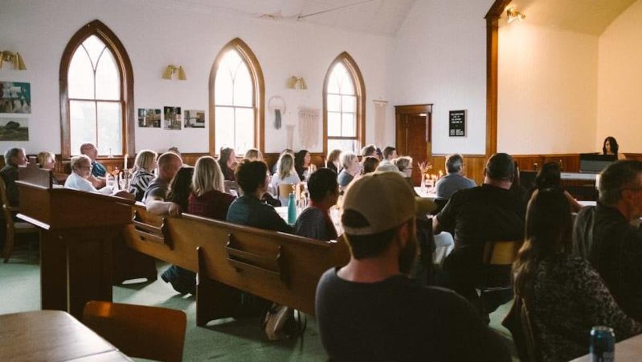 Des gens assistent à un concert, assis dans une église.