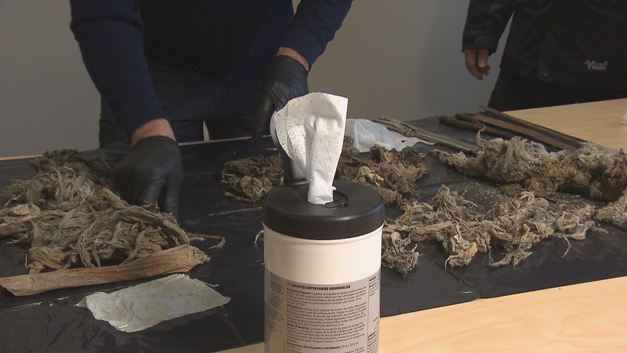 Un homme sort des lingettes souillées des égouts.