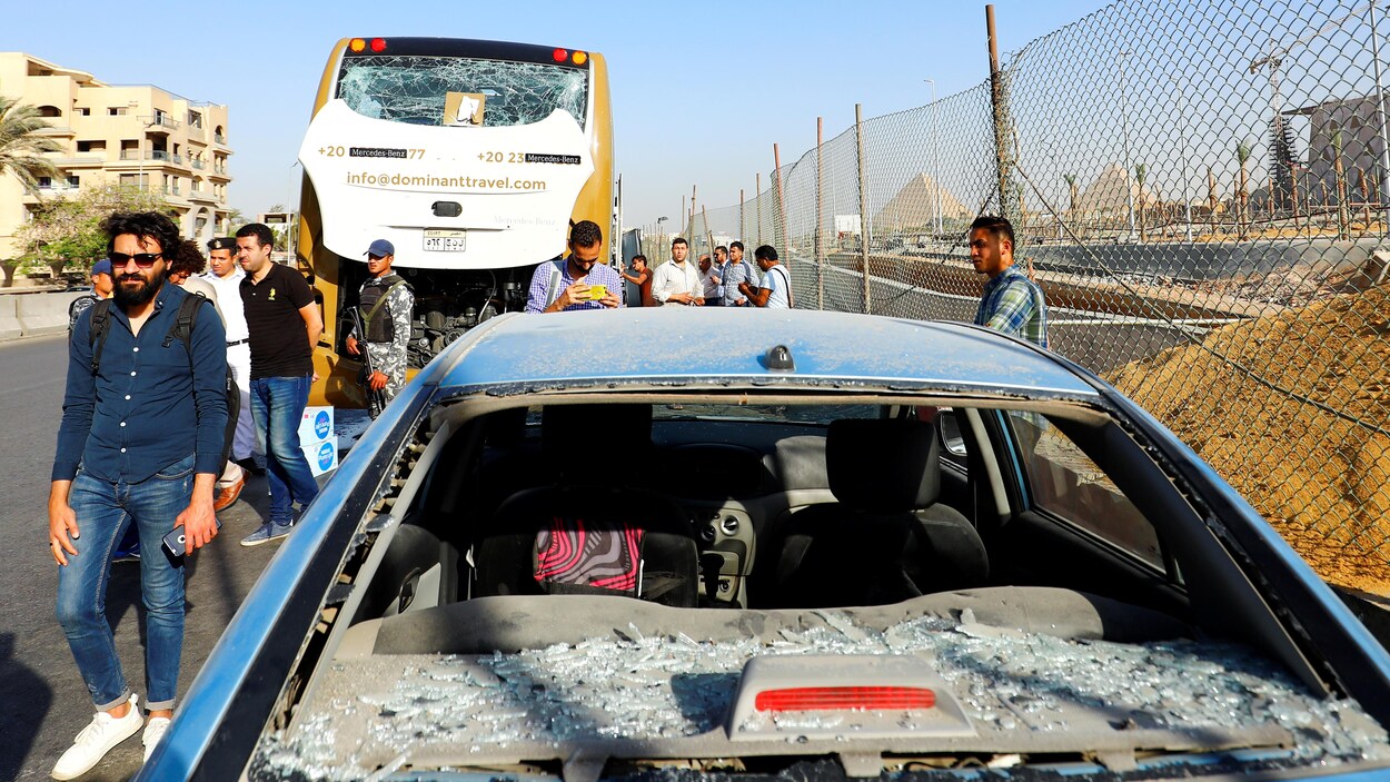 L'autobus et l'auto endommagés par l'explosion qui a fait 17 blessés non loin du site des pyramides.