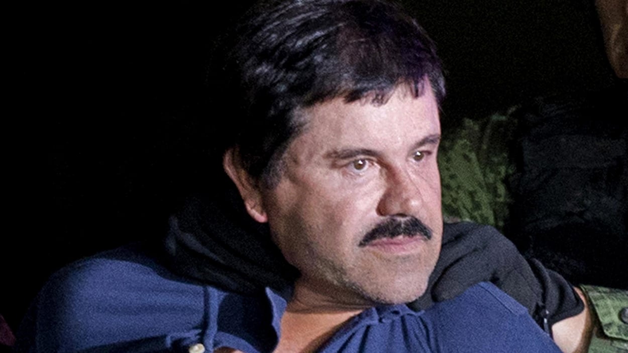 Un homme retenu par des policiers.