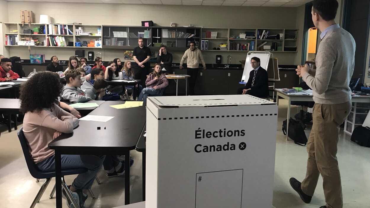 Des enfants dans une classe écoutent un professeur.