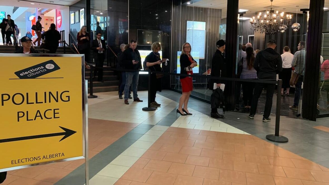 Des personnes font la queue devant un bureau de vote dans le centre commercial City Centre du centre-ville d'Edmonton.