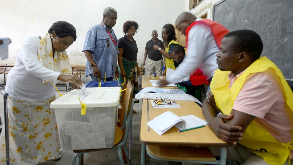 Des femmes et des hommes dans un bureau de vote.