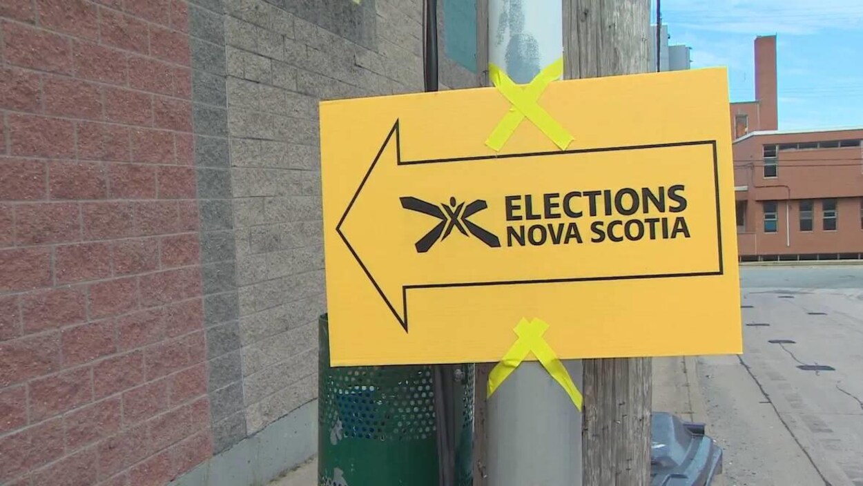 Affiche jaune d'Élections Nouvelle-Écosse avec une flèche pointant vers un bureau de vote.