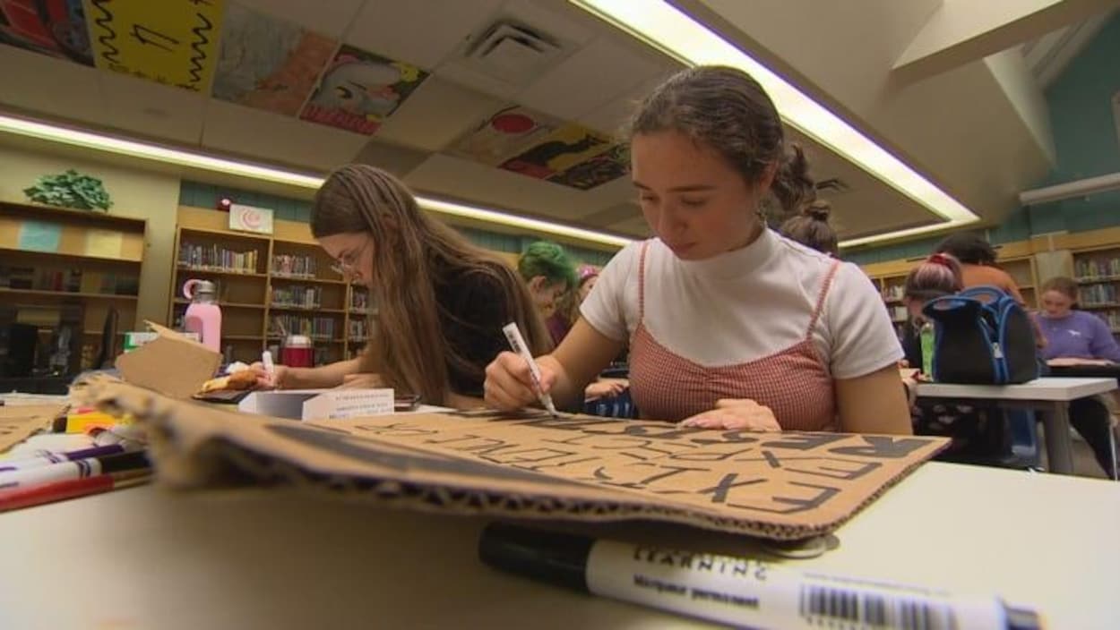 Des élèves du secondaire de Winnipeg ont fabriquent des pancartes de protestation en carton recyclé dans une école.