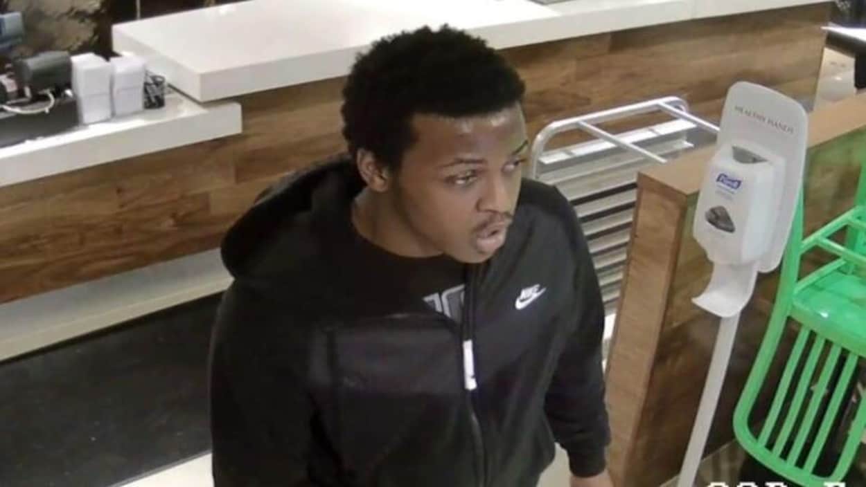 Un jeune homme portant un sweatshirt à capuche noir.