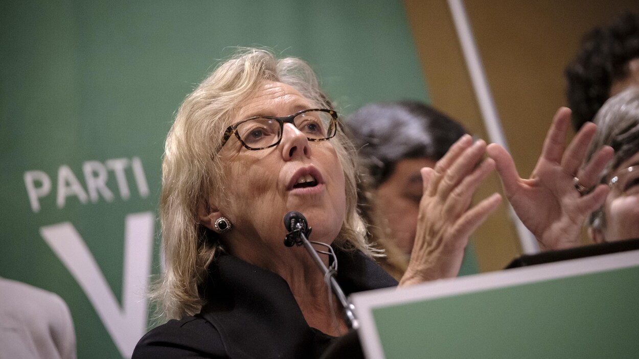 Mme May prend la parole derrière un lutrin.