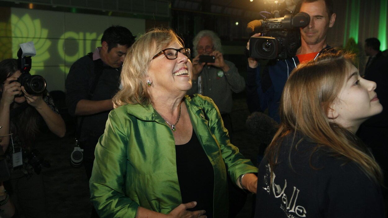Elle lève la tête vers un écran.