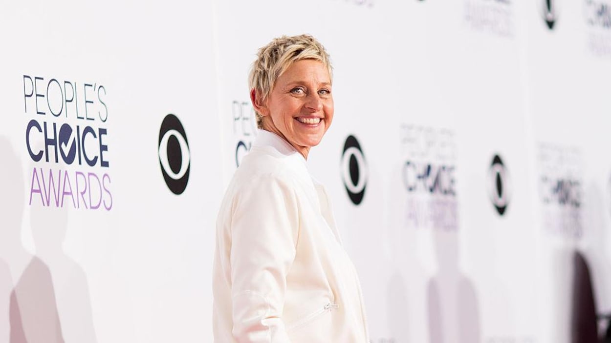 Ellen DeGeneres pose vêtue de blanc.