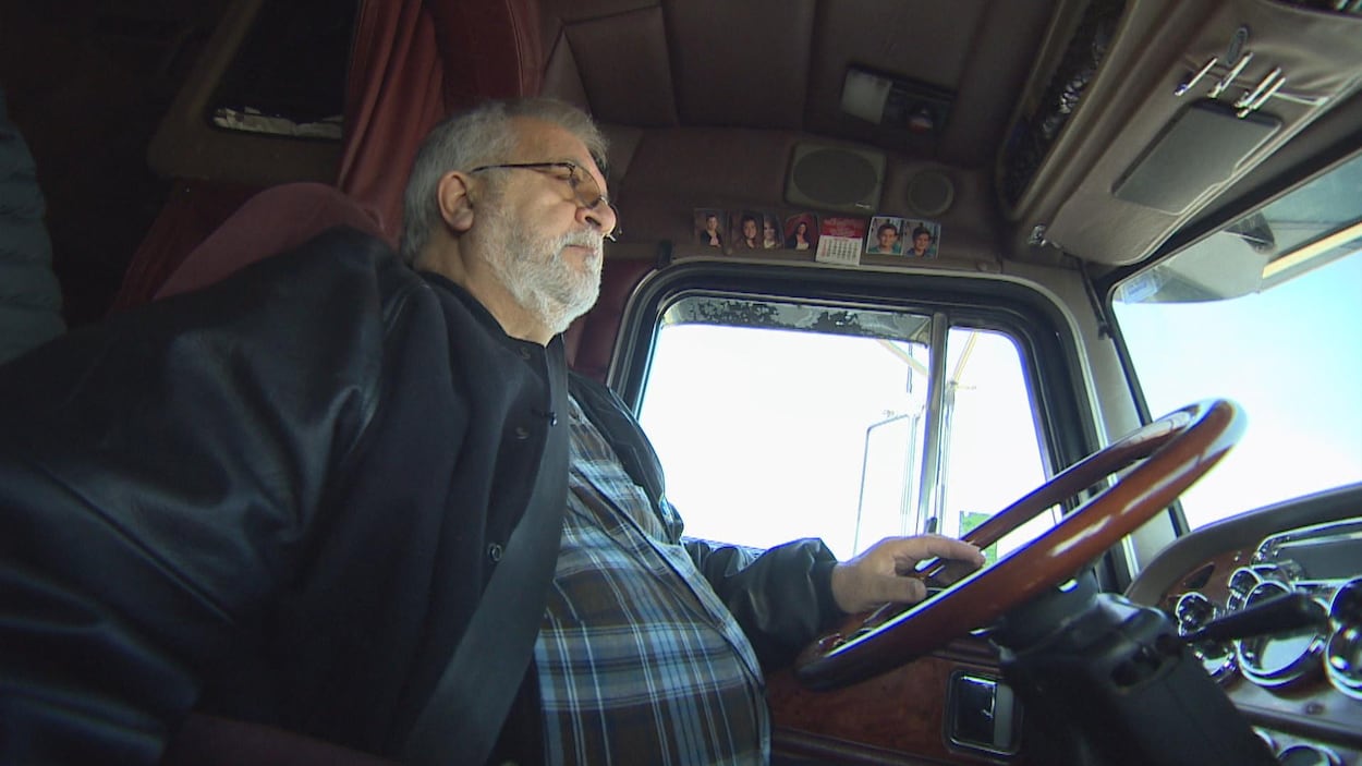 Un homme photographié dans la cabine d'un semi-remorque. Un homme photographié dans la cabine d'un semi-remorque.