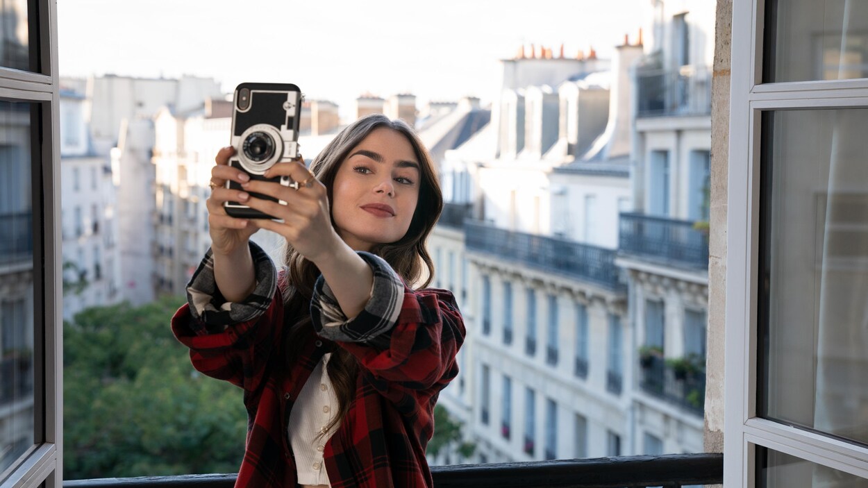 La comédienne prend un égoportrait devant le cadre d'une fenêtre donnant sur le quartier Montmartre, à Paris.